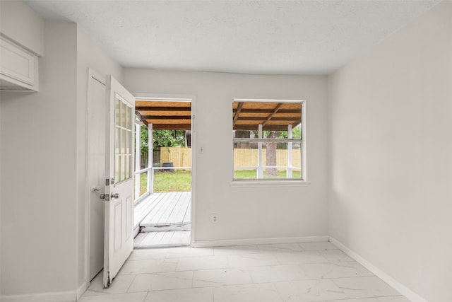 entryway with a textured ceiling and light tile floors