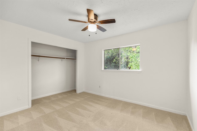 unfurnished bedroom with light carpet, a closet, and ceiling fan