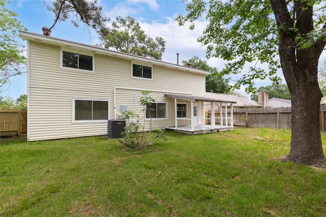 rear view of house with central AC, a patio area, and a yard