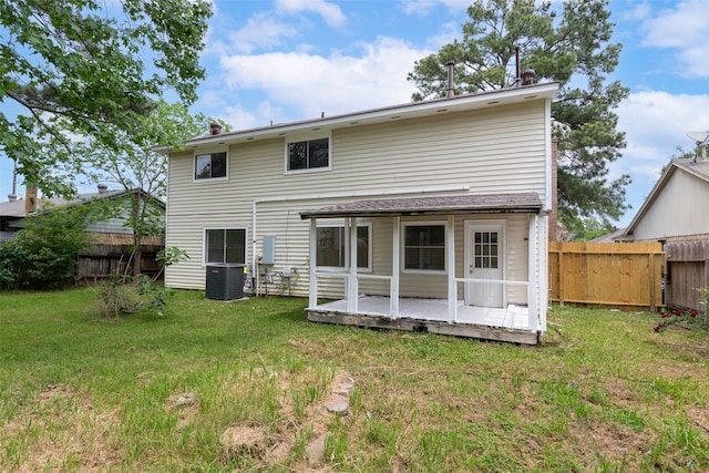 back of property featuring central AC and a lawn