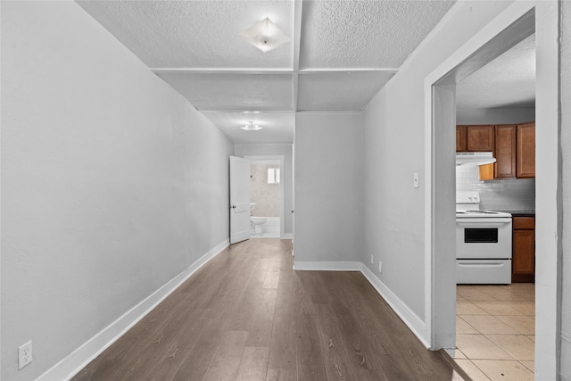 corridor featuring a textured ceiling and light hardwood / wood-style flooring