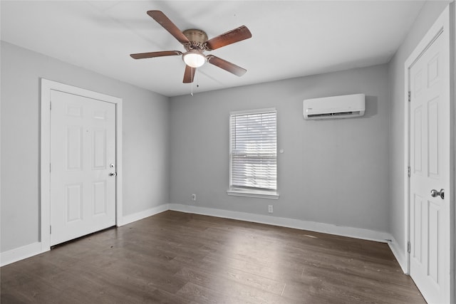 spare room featuring ceiling fan, dark wood-type flooring, and an AC wall unit