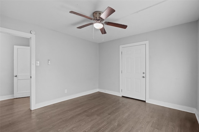 spare room with dark wood-type flooring and ceiling fan