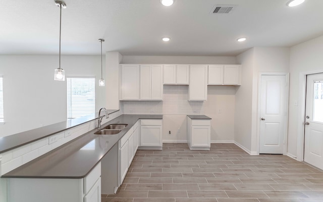 kitchen with white cabinets, sink, and a wealth of natural light