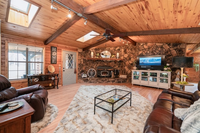 living room featuring wooden walls, a fireplace, ceiling fan, and light hardwood / wood-style flooring