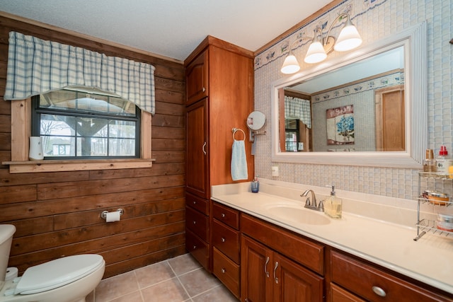 bathroom featuring toilet, tile floors, wood walls, a textured ceiling, and vanity