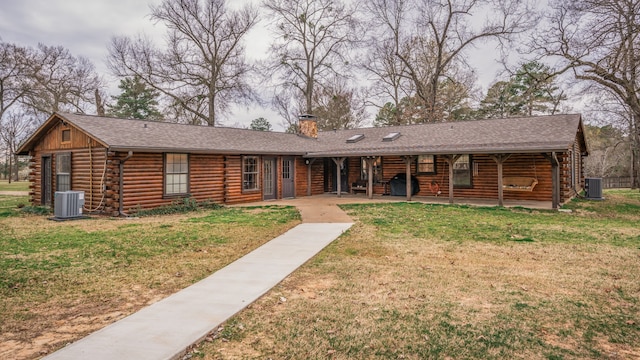 log home with central AC unit and a front yard