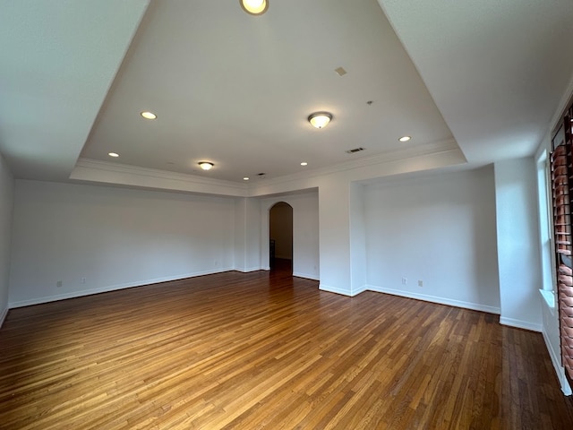 unfurnished room with wood-type flooring and a raised ceiling