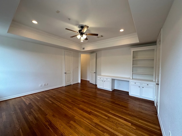 empty room with ceiling fan, crown molding, a raised ceiling, and dark wood-type flooring