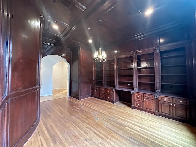 interior space with an inviting chandelier, coffered ceiling, built in shelves, and light wood-type flooring