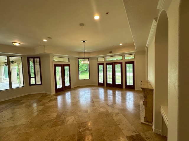 tiled spare room featuring french doors, crown molding, a raised ceiling, and plenty of natural light