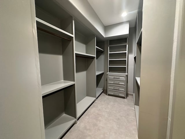 walk in closet featuring light tile floors