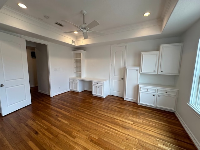 unfurnished room featuring a raised ceiling, ornamental molding, ceiling fan, and hardwood / wood-style flooring