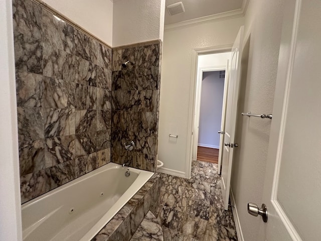 bathroom featuring crown molding, tiled shower / bath, and tile flooring