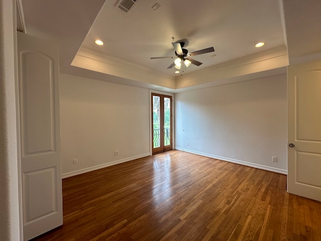 spare room with ceiling fan, a raised ceiling, french doors, dark hardwood / wood-style flooring, and ornamental molding