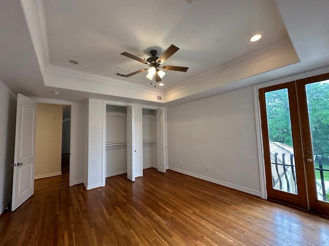 unfurnished bedroom featuring hardwood / wood-style floors, ceiling fan, access to exterior, a tray ceiling, and french doors