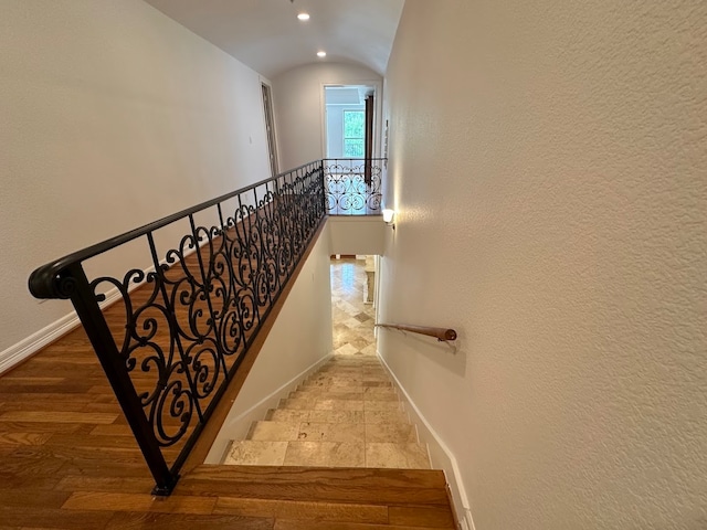 stairs featuring vaulted ceiling and light tile floors