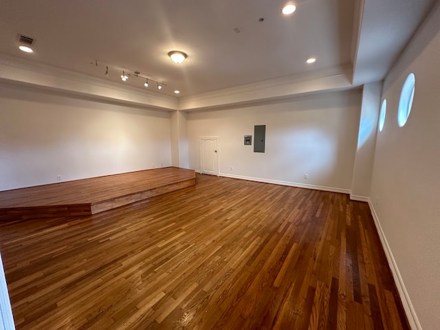 unfurnished room featuring track lighting, dark hardwood / wood-style floors, and a tray ceiling