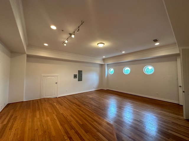 spare room featuring rail lighting, crown molding, and hardwood / wood-style floors