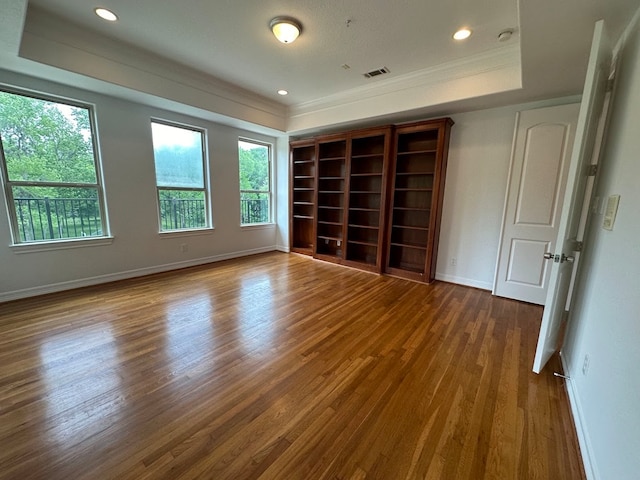 unfurnished room with a raised ceiling and hardwood / wood-style flooring