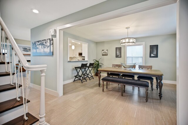 dining area with light hardwood / wood-style flooring and an inviting chandelier