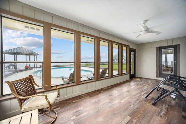 sunroom featuring ceiling fan