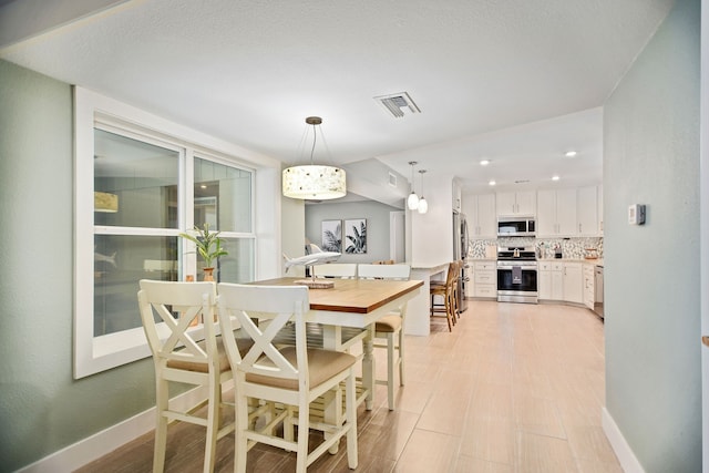 dining area with an inviting chandelier and light wood-type flooring