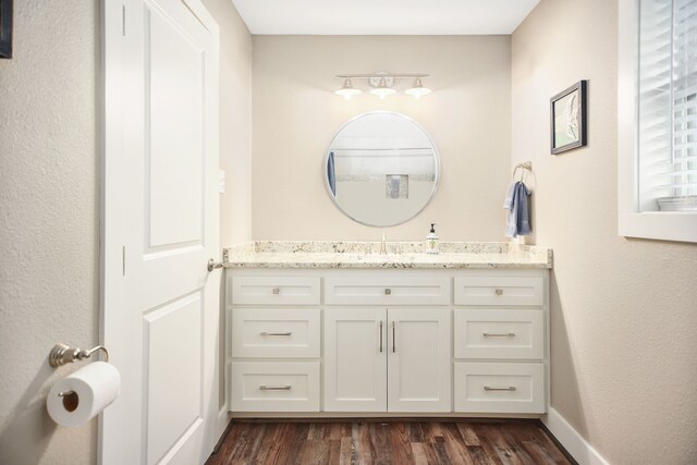 bathroom with vanity with extensive cabinet space and wood-type flooring