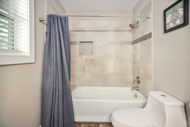 bathroom with shower / tub combo, hardwood / wood-style flooring, and toilet