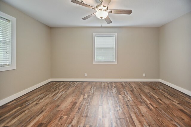 spare room with ceiling fan and dark wood-type flooring