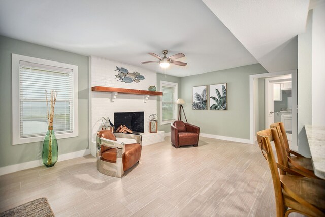 living room with ceiling fan and a brick fireplace