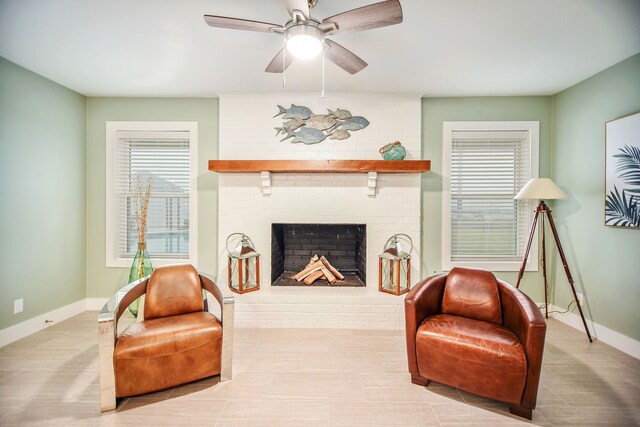 living room with brick wall, ceiling fan, and a fireplace