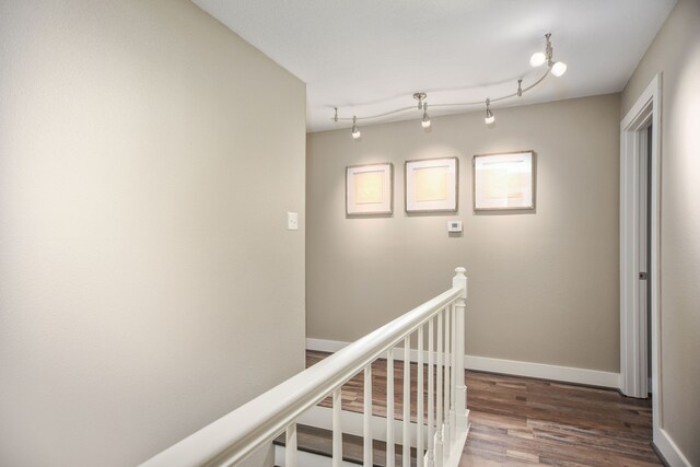 hallway with dark wood-type flooring and rail lighting