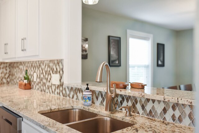 kitchen featuring white cabinets, sink, and tasteful backsplash