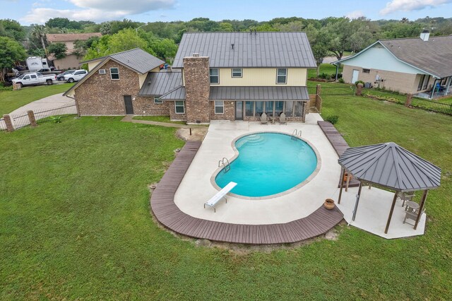 view of swimming pool featuring a diving board, a yard, and a patio area