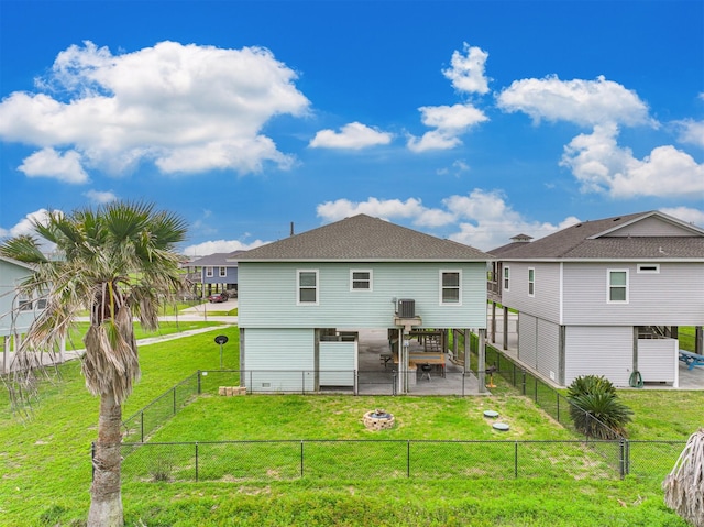 rear view of property with a fire pit, a lawn, and a patio