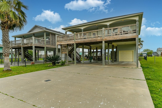 view of front of home featuring a garage, a deck, a front lawn, and a carport