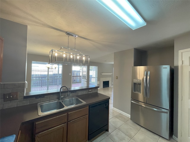 kitchen with decorative light fixtures, black dishwasher, a healthy amount of sunlight, stainless steel refrigerator with ice dispenser, and sink