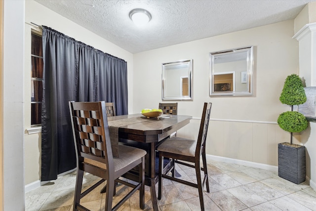 dining space with light tile flooring and a textured ceiling