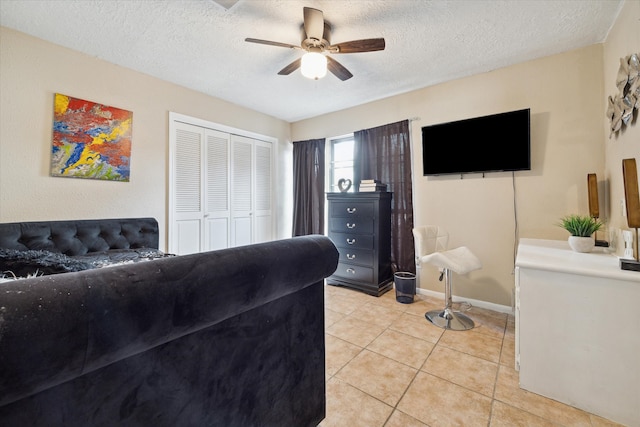 tiled living room featuring ceiling fan and a textured ceiling