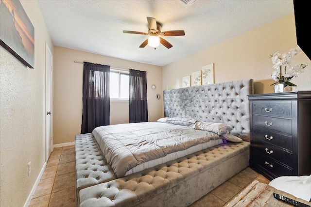 tiled bedroom with a textured ceiling and ceiling fan