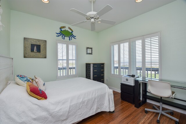 bedroom featuring dark hardwood / wood-style floors, ceiling fan, and multiple windows