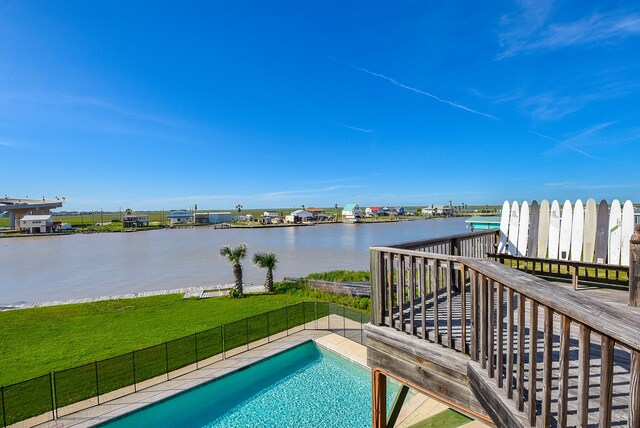 view of pool with a yard and a water view