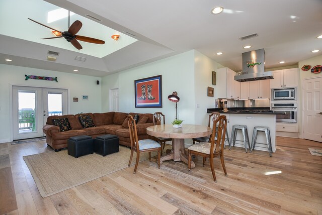 living room featuring french doors, light hardwood / wood-style floors, and ceiling fan