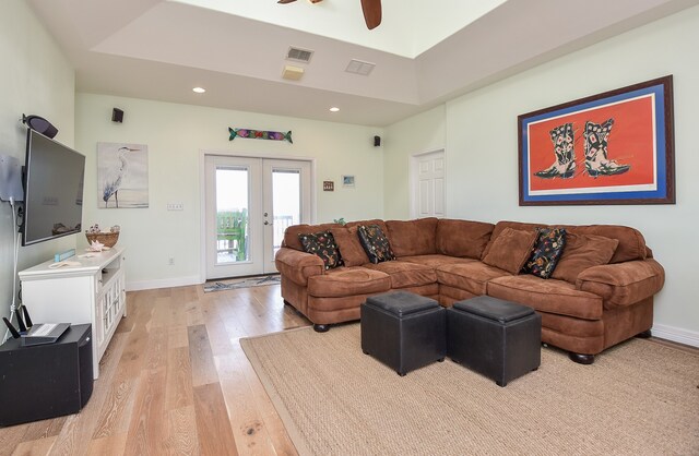 living room featuring french doors, ceiling fan, and light wood-type flooring