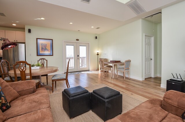 living room with french doors and light wood-type flooring