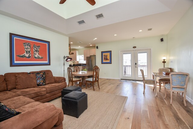 living room featuring french doors, ceiling fan, and light hardwood / wood-style floors