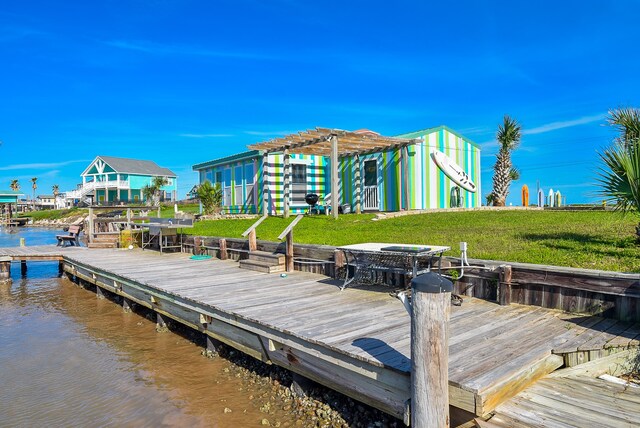 dock area with a yard, a deck with water view, and a pergola