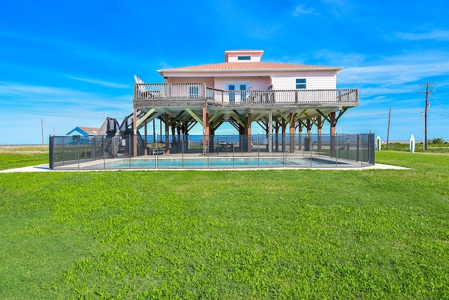 back of property with a fenced in pool, a yard, and a balcony