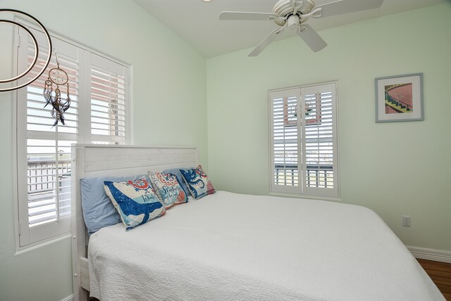 bedroom with hardwood / wood-style floors, multiple windows, and ceiling fan